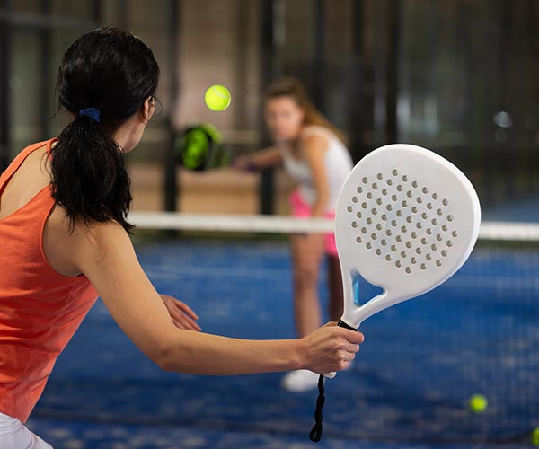 Two young ladies playing paddle tennis